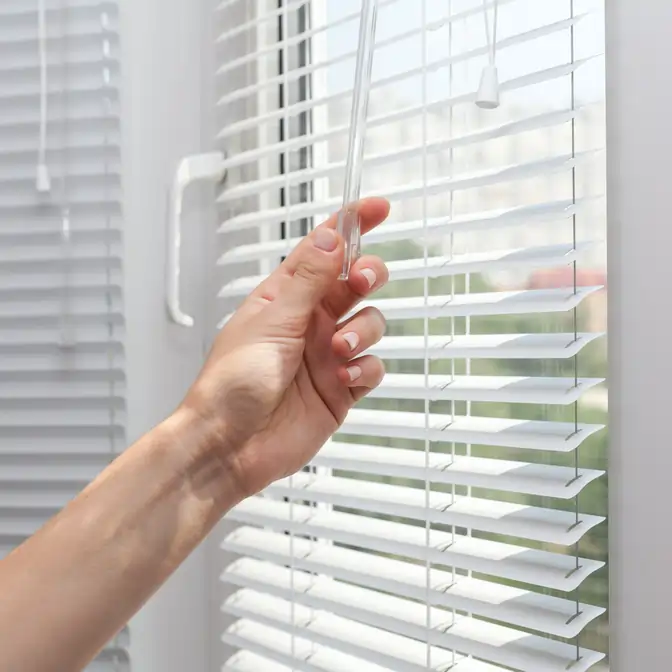 Zbliżenie na uchwyt do regulacji lameli żaluzji aluminiowych w oknie we Władysławowie