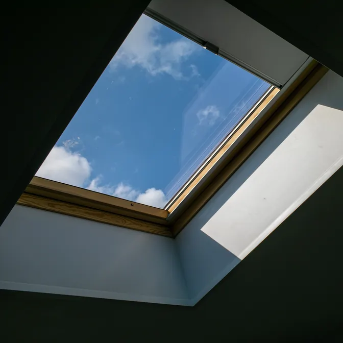 Zbliżenie na roletę materiałową na prowadnicy okna dachowego w Rumii