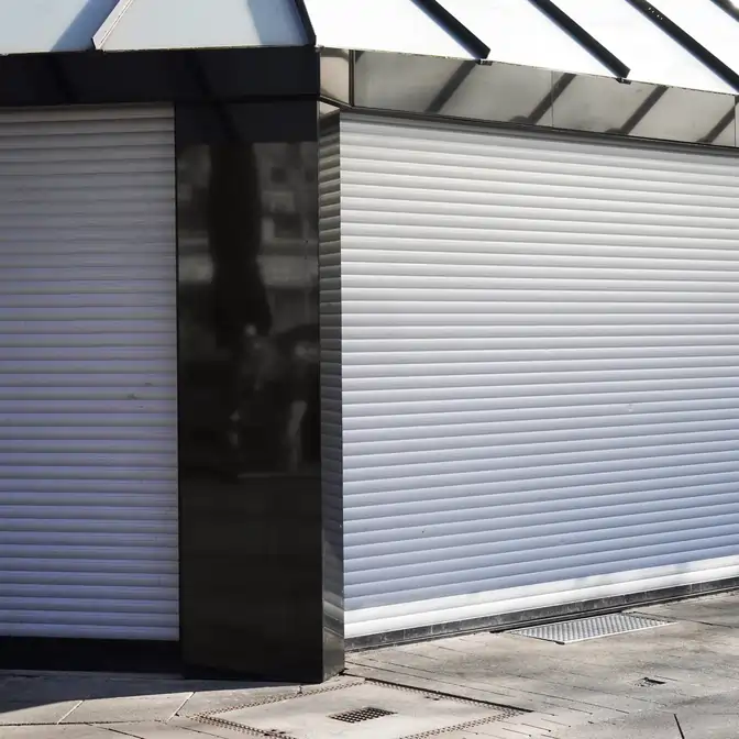 Front sklepu w Tczewie z opuszczonymi roletami zewnętrznymi w odcieniu szarości