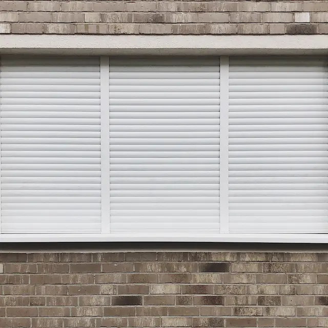 Zewnętrzna roleta w kolorze białym zamontowana w dolnej kondygnacji budynku w Sopocie