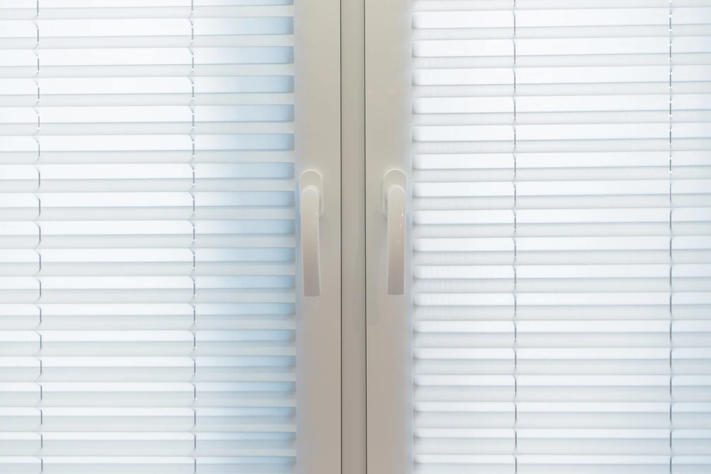 Zbliżenie na strukturę tkaniny rolet plisowanych zamontowanych w biurze w Tczewie