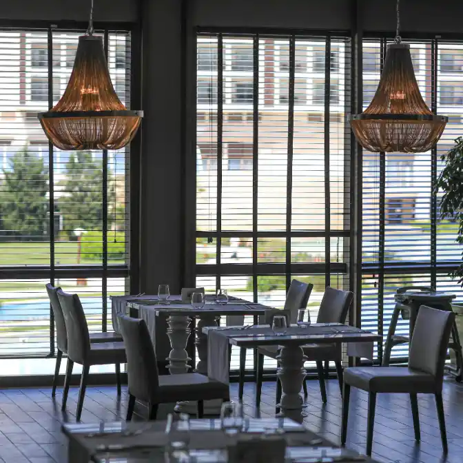 Widok wnętrza Sopockiej restauracji z poziomo ustawionymi lamelami drewnianych żaluzji