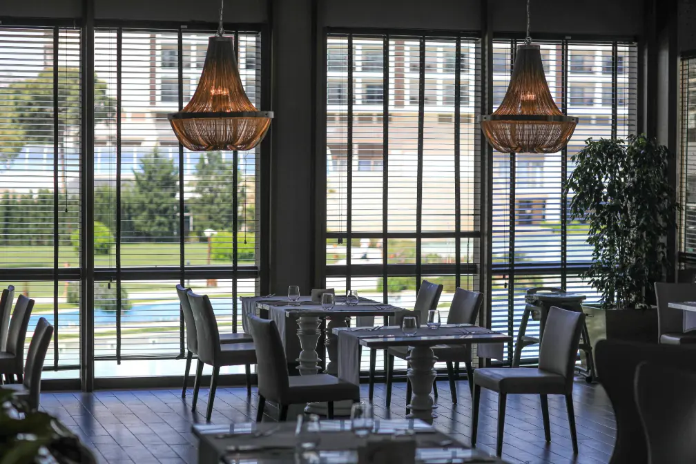 Żaluzje drewniane z lamelami ustawionymi poziomo w Sopockiej restauracji