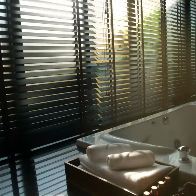 Czarne drewniane żaluzje dodające charakteru łazience w nadmorskim Władysławowie