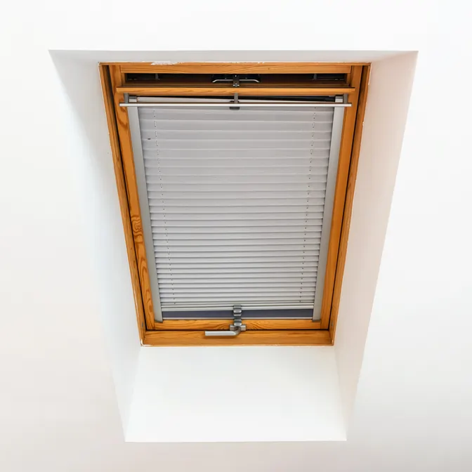 Szara roleta plisowana z prowadnicami na oknie dachowym w Gdańsku