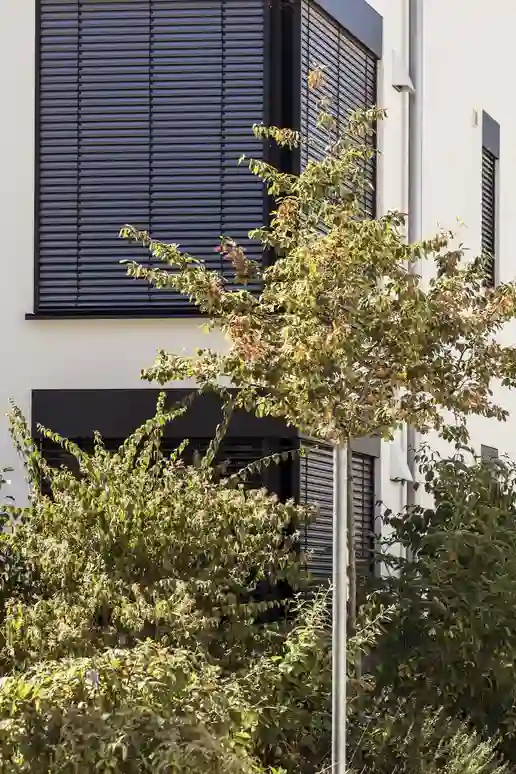 Blok mieszkalny z granatowymi żaluzjami zewnętrznymi