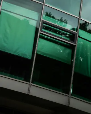 Zbliżenie na okno z roletami materiałowymi w kolorze zielonym