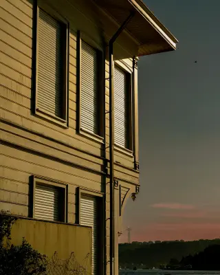 budynek z zasłoniętymi roletami zewnętrznymi podczas zachodu słońca