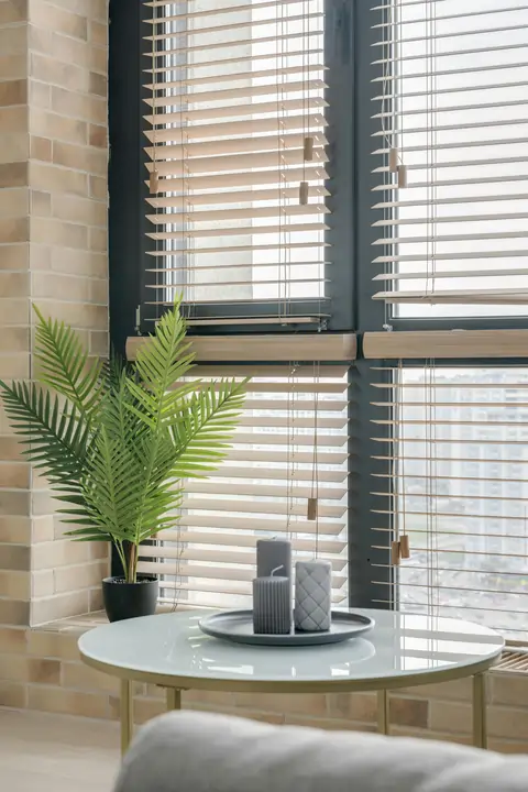 Żaluzje drewniane o jasnym odcieniu w salonie